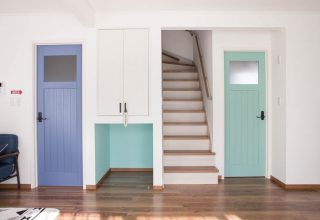 ブルーのドアを中心にした西海岸風インテリアの家の写真