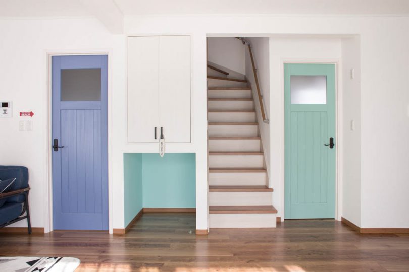 ブルーのドアを中心にした西海岸風インテリアの家の写真
